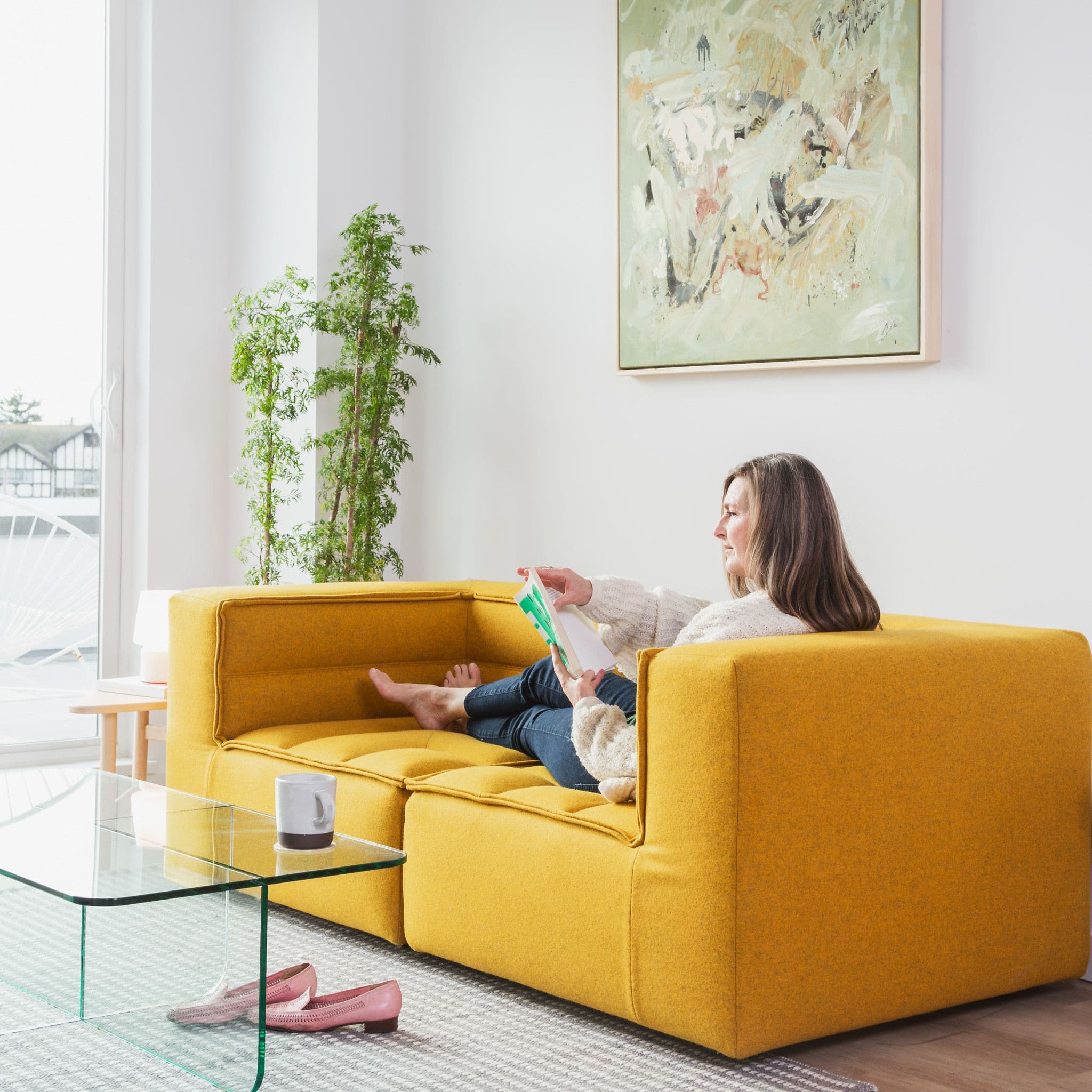 Woman in Centro apartment living room reading magazine